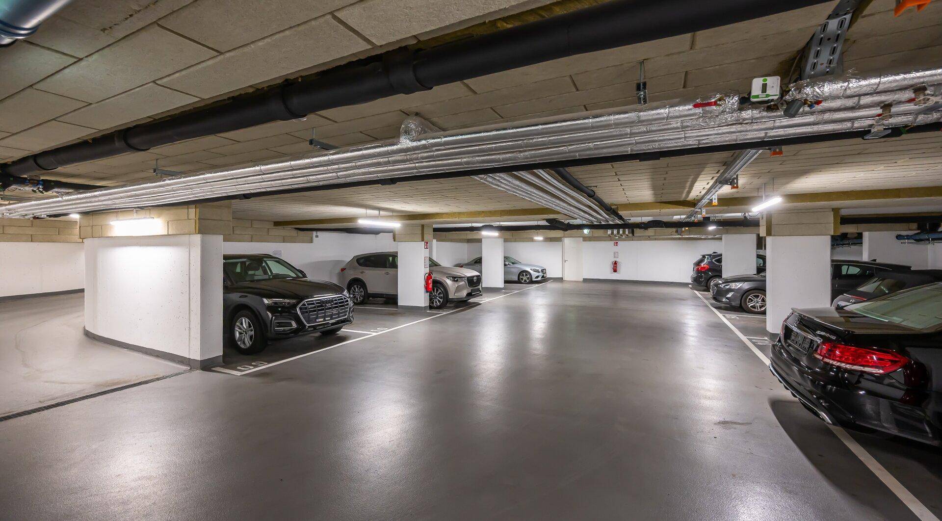 Tiefgarage mit mehreren Stellplätzen und moderner Beleuchtung.
