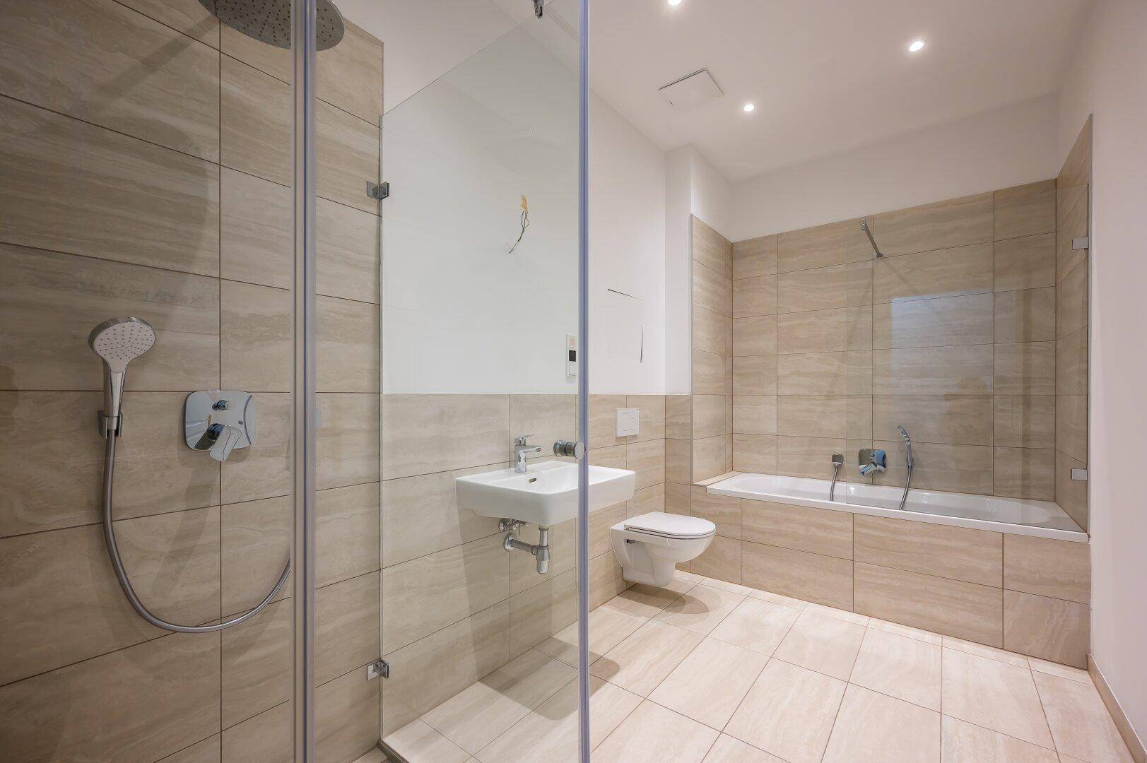 Modernes Badezimmer mit begehbarer Dusche, Badewanne und beigefarbenen Fliesen.