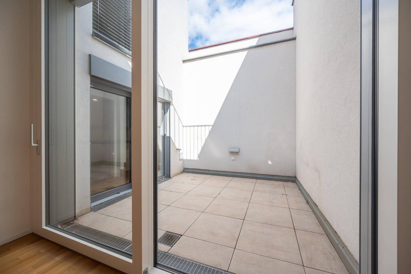 Private Terrasse mit Fliesenboden und Zugang zu den Innenräumen.