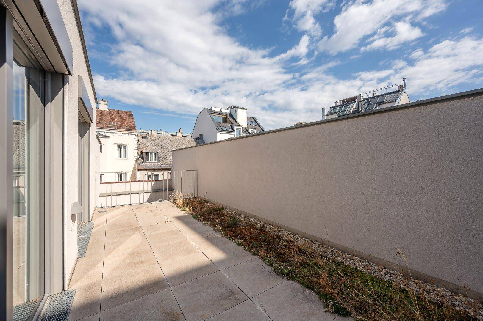 Geräumige Dachterrasse mit Fliesenboden und Blick auf die Nachbarschaft.