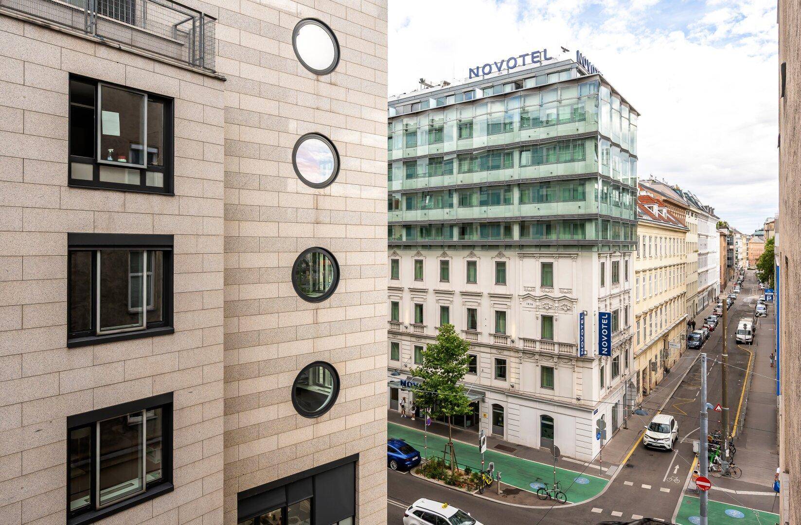 Stadtansicht mit einer Mischung aus moderner und traditioneller Architektur und einer belebten Straße.