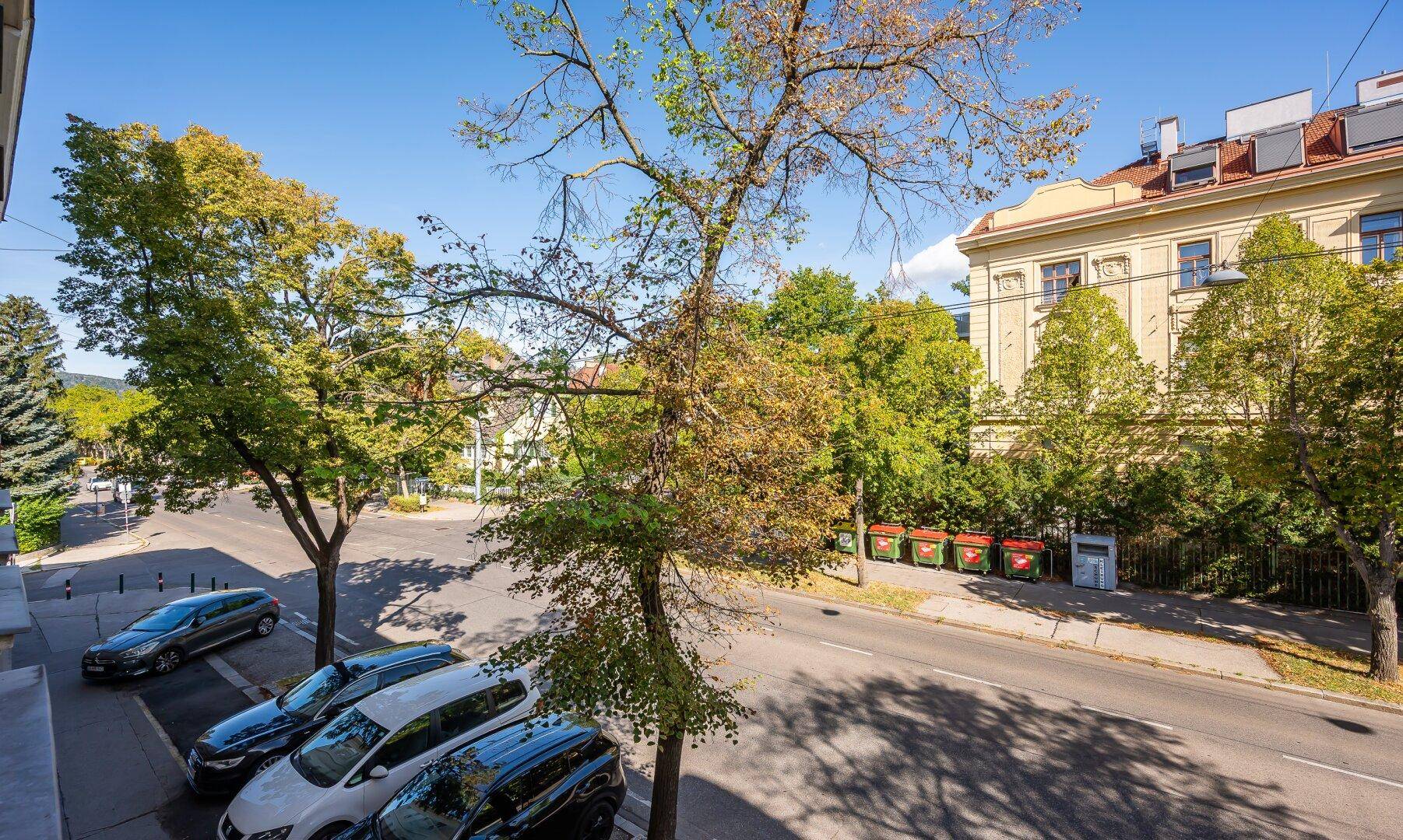Weitläufiger Blick von einem Balkon auf die grüne Umgebung und die Stadt.