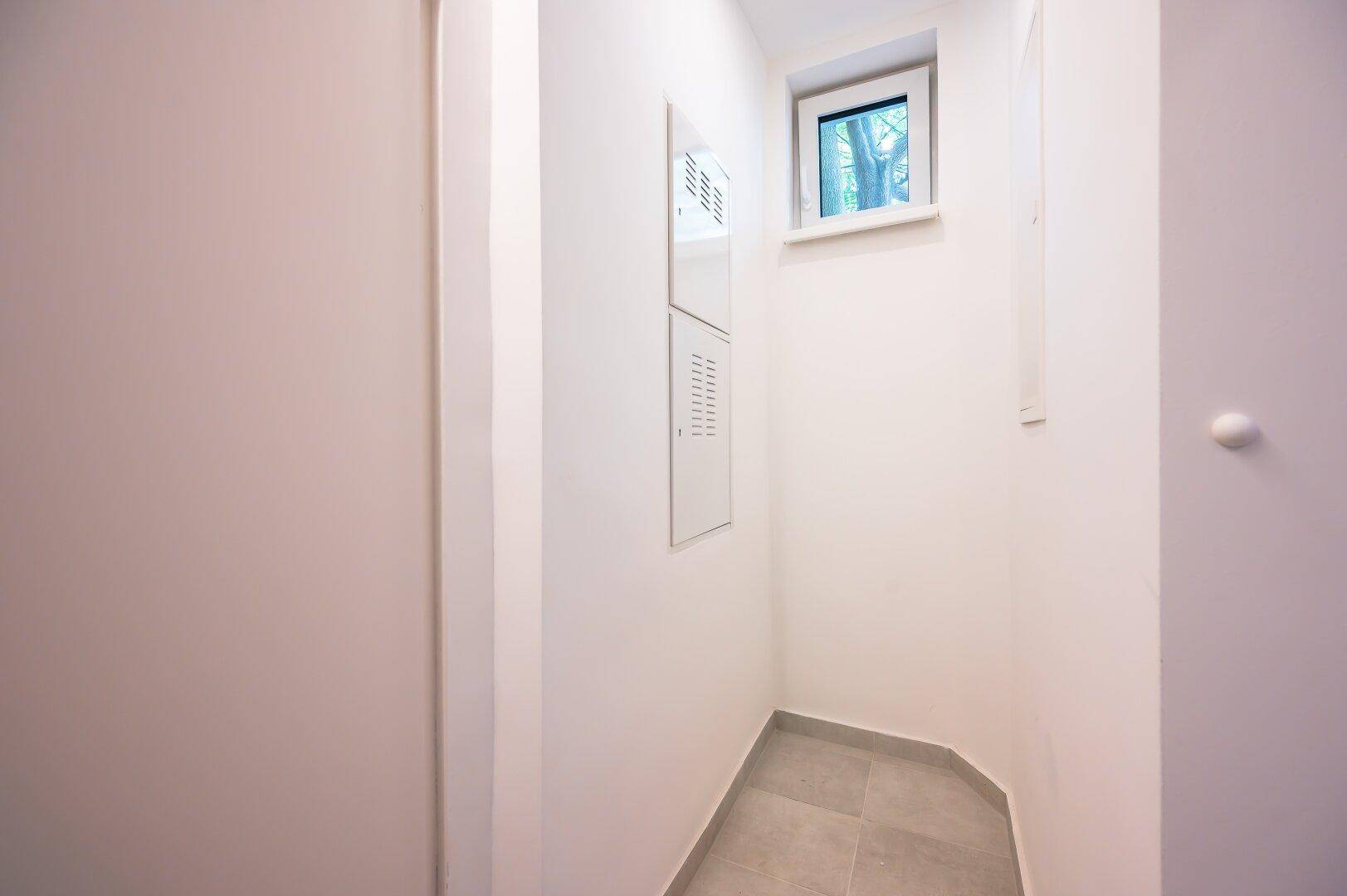 Kleiner Abstellraum mit Fenster und Fliesenboden, ideal für zusätzlichen Stauraum oder Technik.