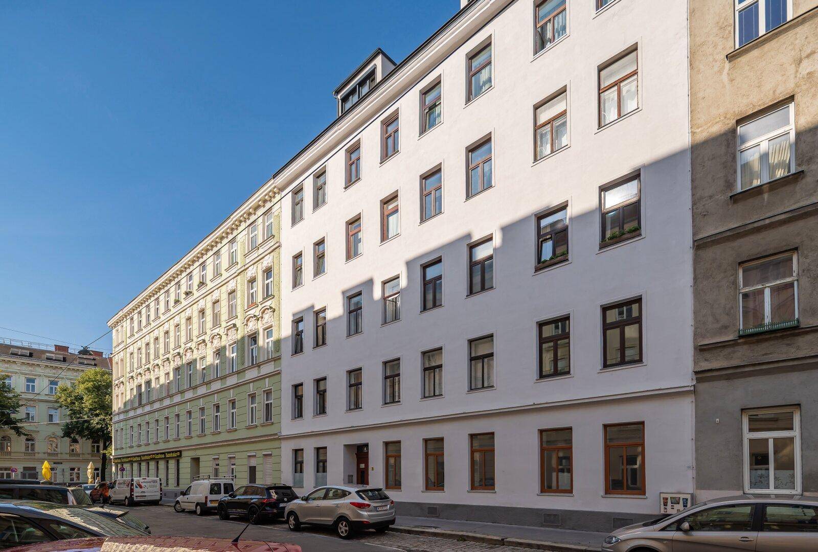 Moderne Gebäudefassade mit vielen Fenstern an einer städtischen Straße.