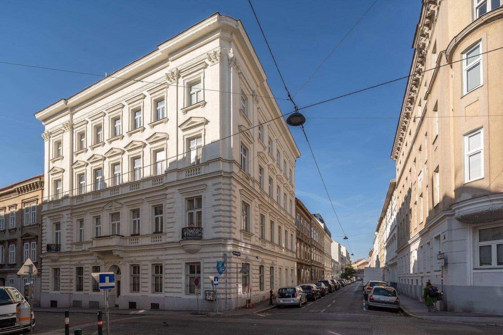 Beeindruckendes Eckgebäude im Altbaustil mit eleganter Fassade und klarem Himmel.