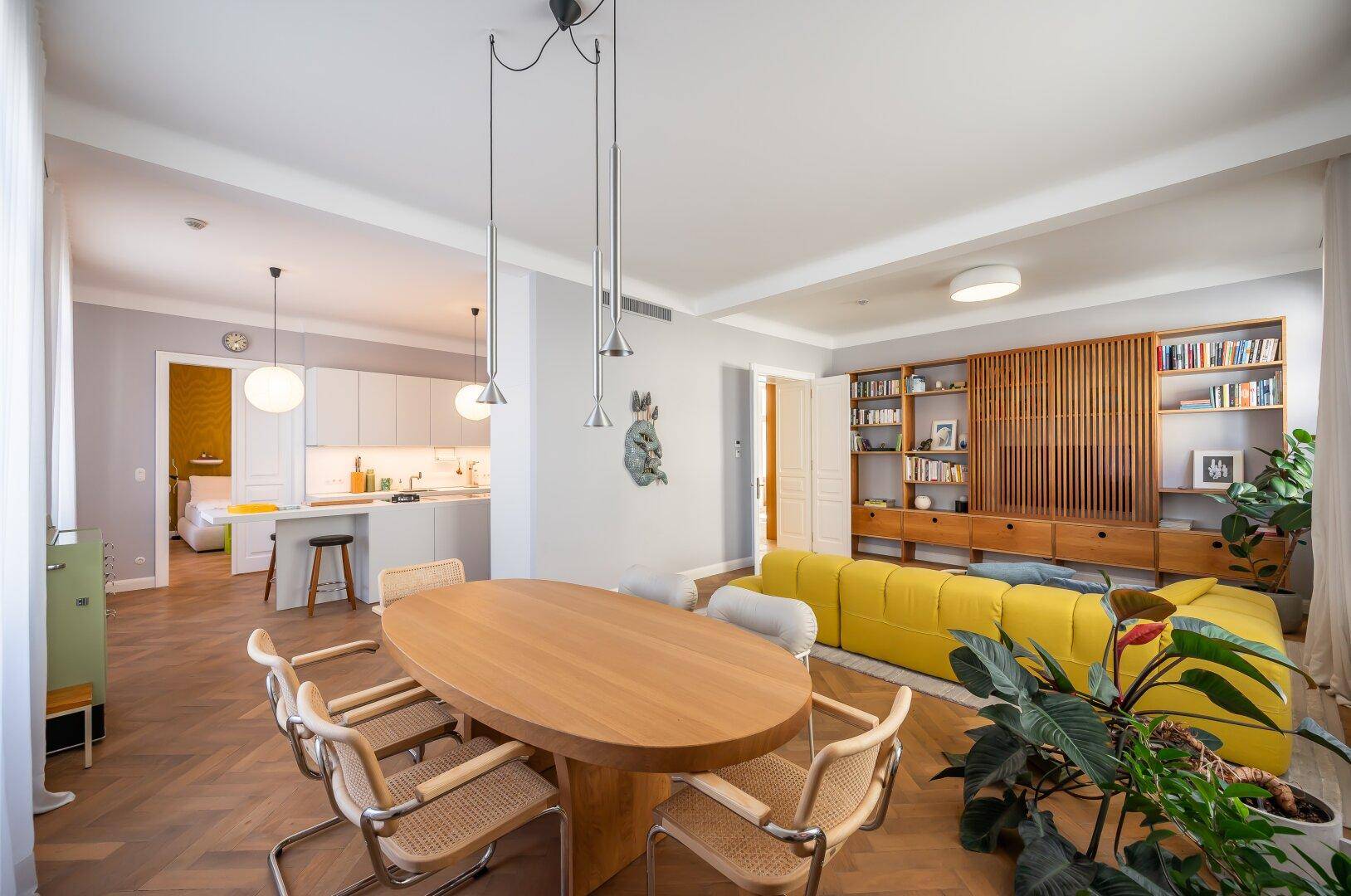 Offener Essbereich mit Holztisch und Stühlen, angrenzend an die moderne Küche und den Wohnbereich.