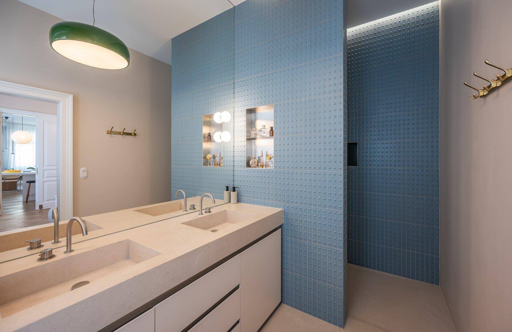 Modernes Badezimmer mit Doppelwaschbecken, blauen Fliesen und begehbarer Dusche.