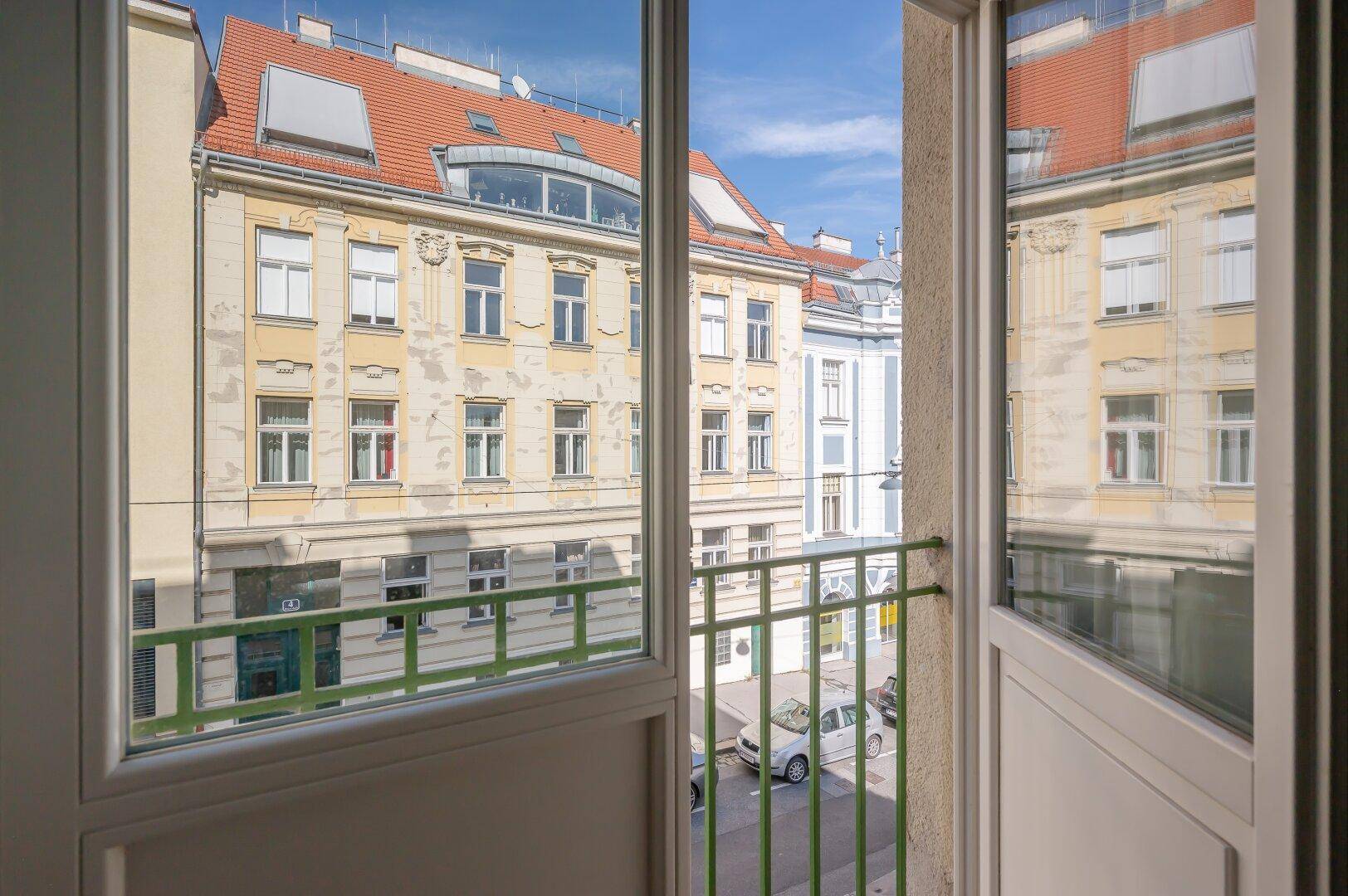 Aussicht von einem französischen Balkon auf die gegenüberliegenden historischen Gebäude und die Straße.
