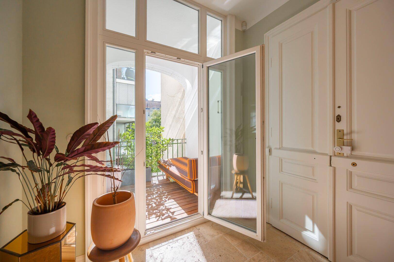 Heller Flur mit Zugang zu einem kleinen Balkon, der viel Tageslicht hereinlässt.