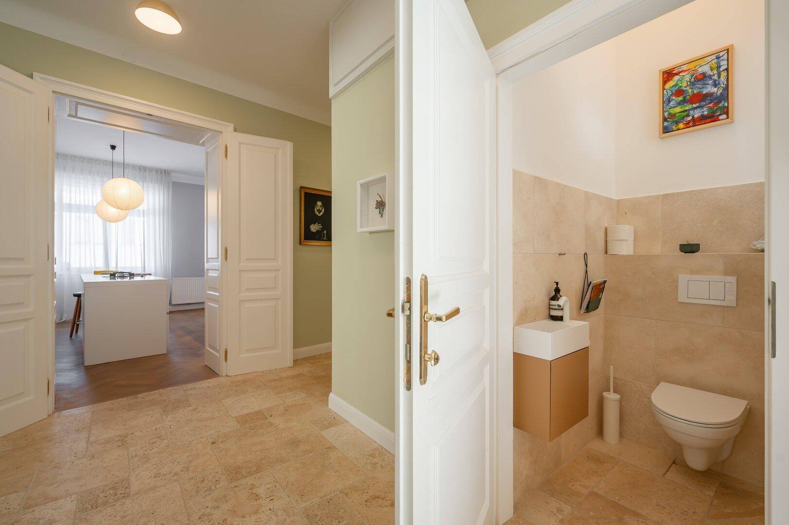 Heller Flur mit Fliesenboden und Zugang zu einem modernen Gäste-WC.