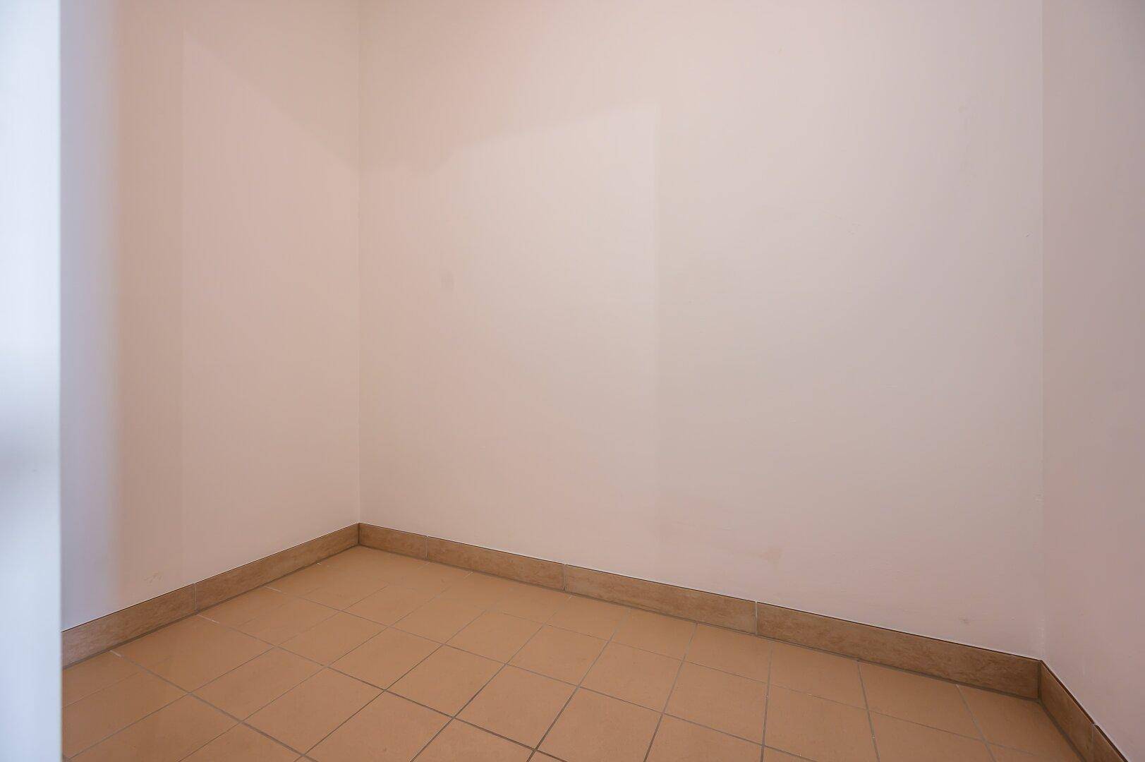 Kleiner, leerer Abstellraum mit Fliesenboden, ideal für zusätzlichen Stauraum im Haushalt.