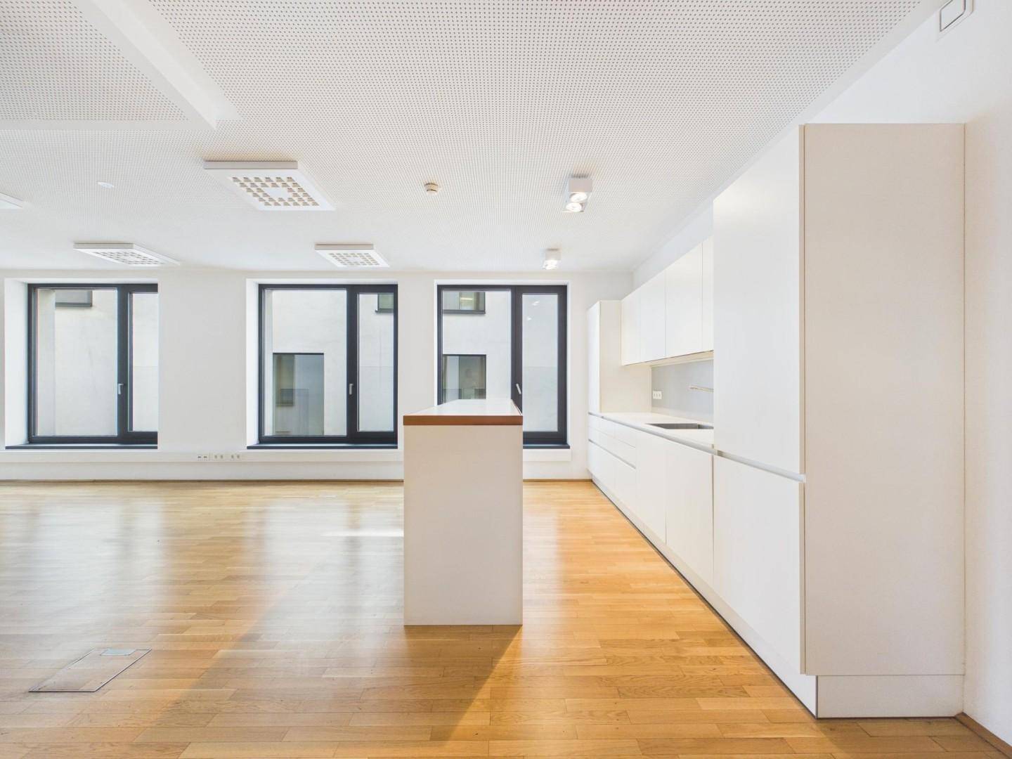 Helle Küchenzeile mit minimalistischem Design und viel Stauraum in einem offenen Raum.