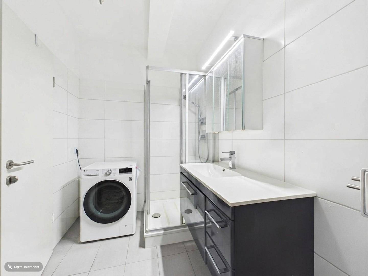 Modernes Badezimmer mit Dusche, Waschbeckenunterschrank und Waschmaschine.