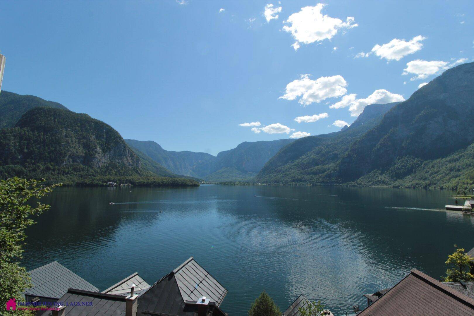 Klarer Blick auf den See und die majestätischen Berge unter strahlend blauem Himmel.