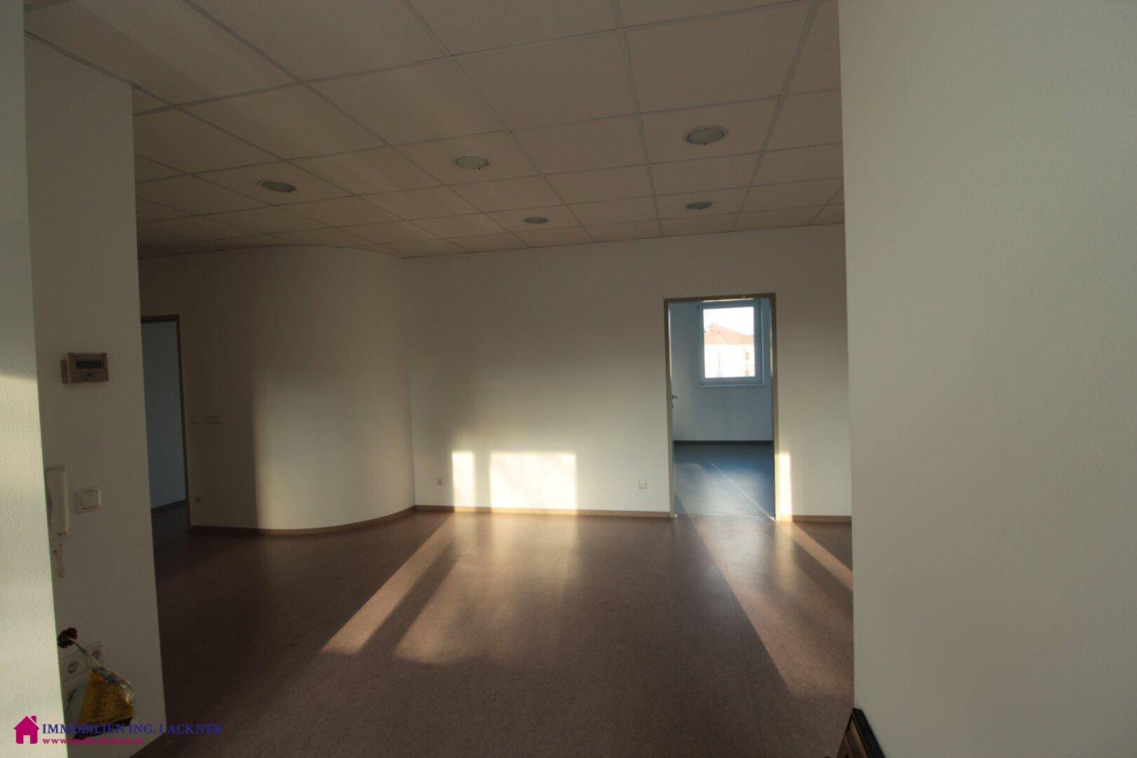 Helles Büro mit hellem Boden und einem Fenster, das viel Tageslicht hereinlässt.