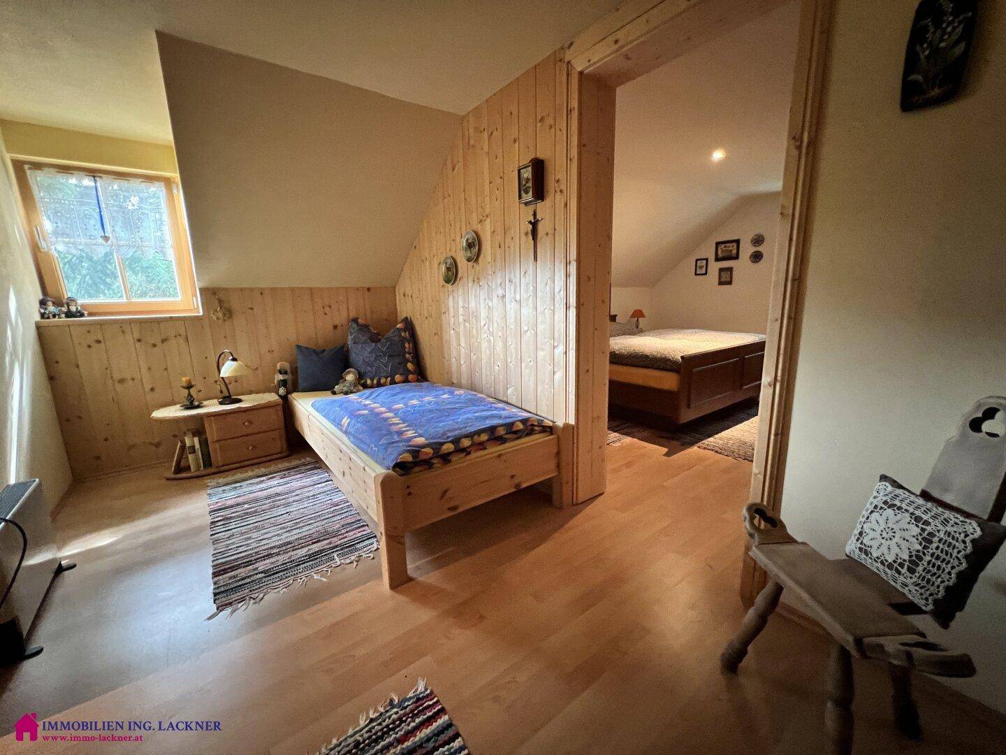 Gemütliche Schlafzimmer im Dachgeschoss mit Holzvertäfelung, Holzboden und schrägen Decken.