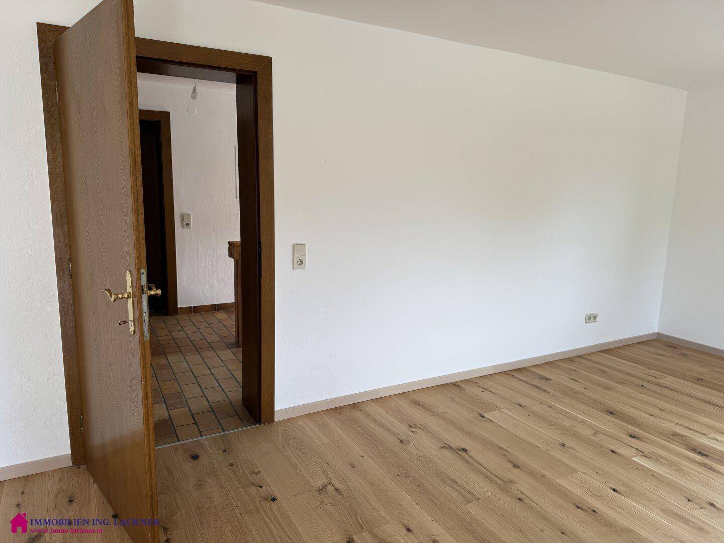 Helles Zimmer mit neuem Holzboden und weiß gestrichenen Wänden, bereit zur individuellen Gestaltung.