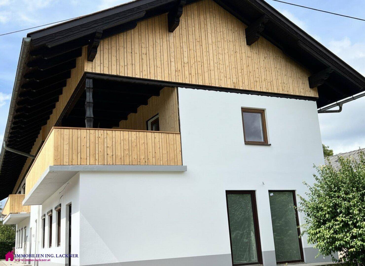 Attraktives Haus mit traditionellem Holzbalkon und moderner Fassadengestaltung.