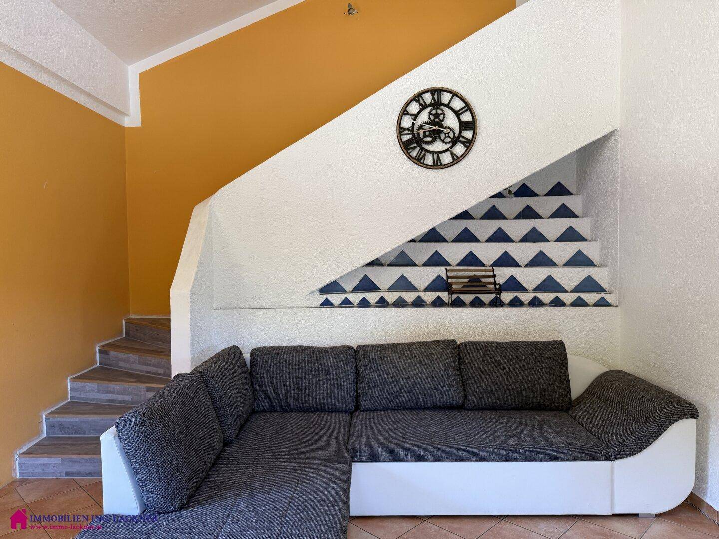 Gemütliche Sitzecke im Wohnzimmer unter der Treppe mit dekorativer Wandgestaltung.