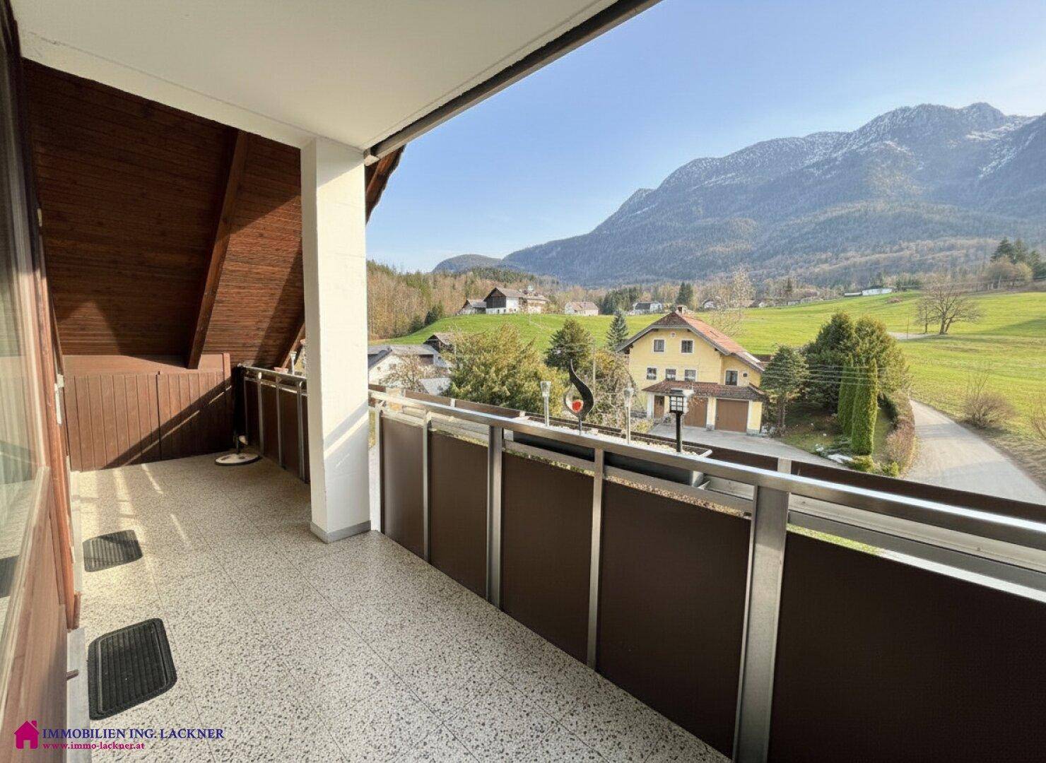 Langer Balkon mit Fliesenboden und Geländer, bietet einen weiten Blick auf die Berge und die ländliche Umgebung.