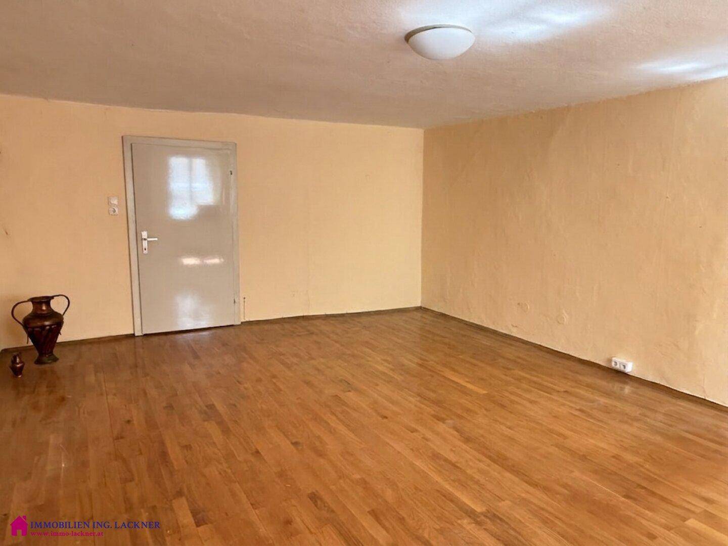 Leerer Raum mit Holzboden und gelben Wänden, bereit zur individuellen Gestaltung.