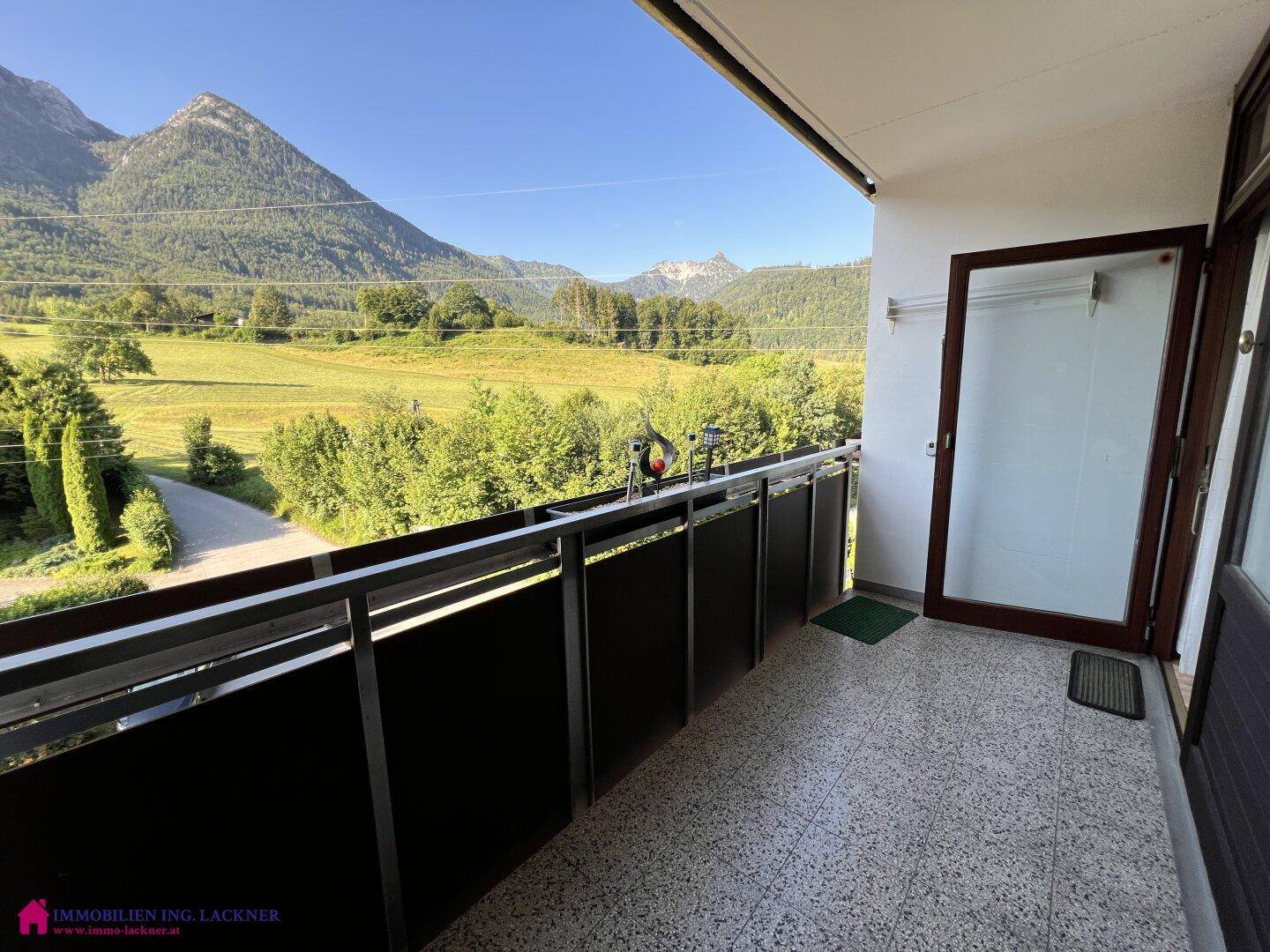 Geräumiger Balkon mit Fliesenboden und weitem Blick auf die umliegende Berglandschaft.
