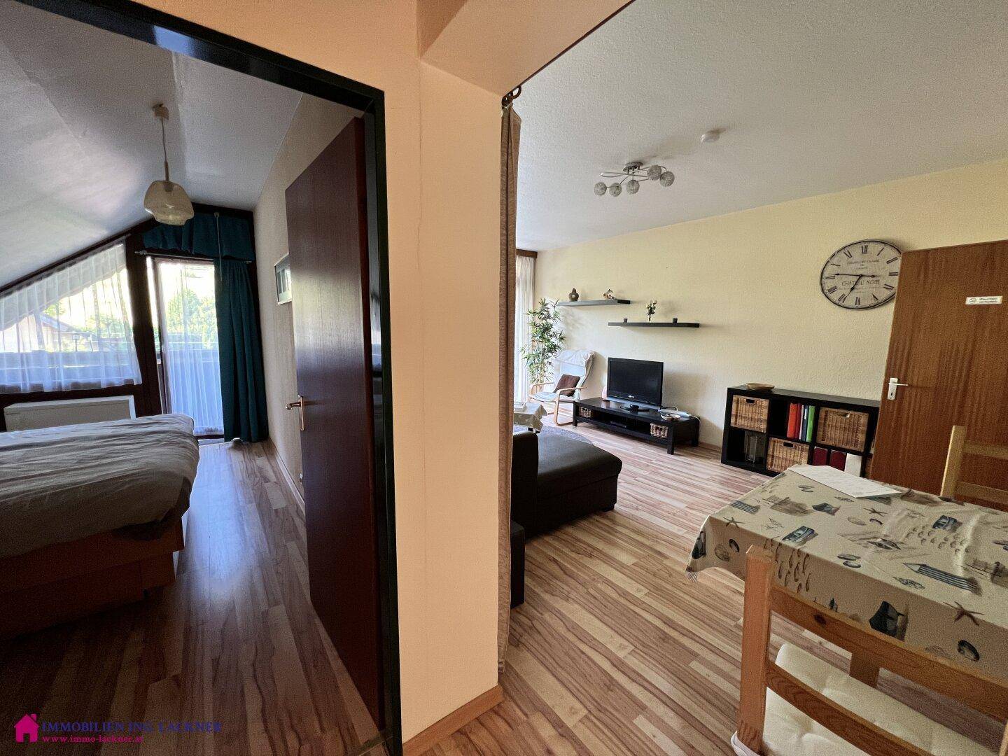 Blick vom Essbereich in das Schlafzimmer und den Wohnbereich mit Laminatboden und schrägen Decken.