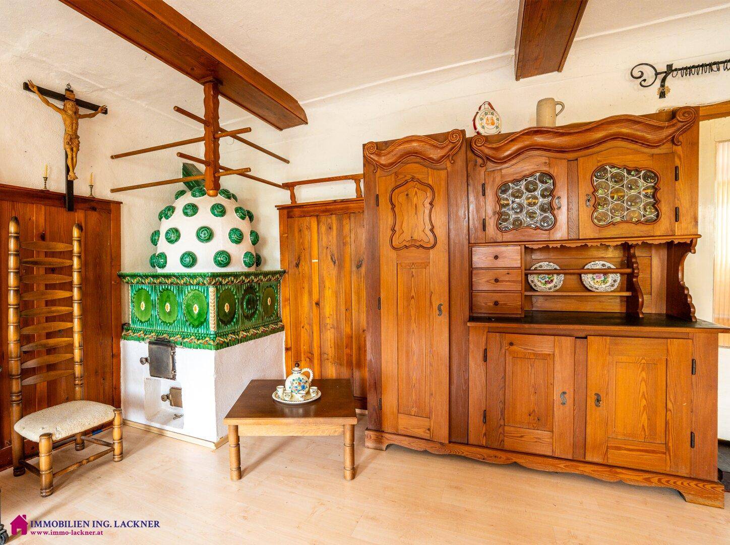 Traditionelles Wohnzimmer im alpinen Stil mit Kachelofen, Holzbalken und rustikalen Möbeln.