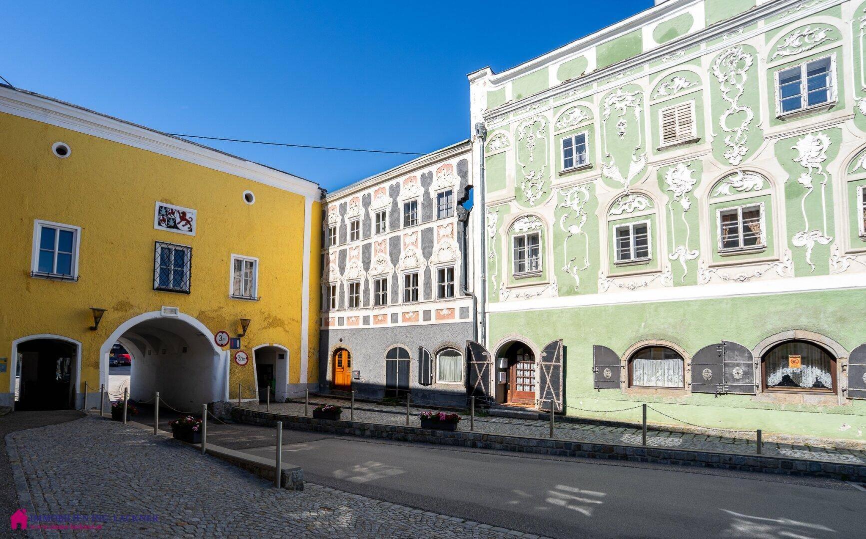 Malerische Gasse mit historischen Gebäuden, farbenfrohen Fassaden und traditionellen Fensterläden.