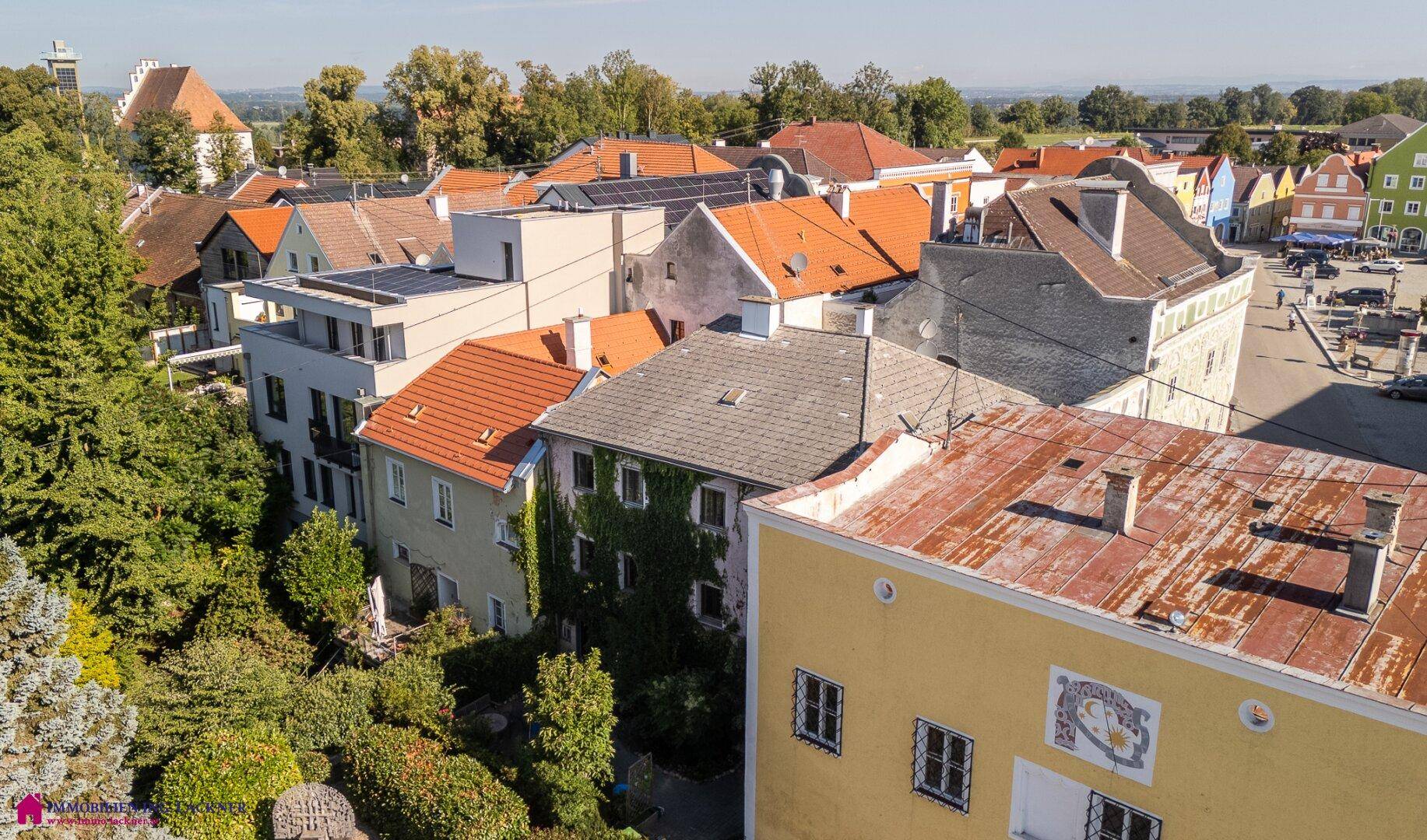 Weitläufige Dachlandschaft einer historischen Stadt mit verschiedenen Gebäuden und Dächern.