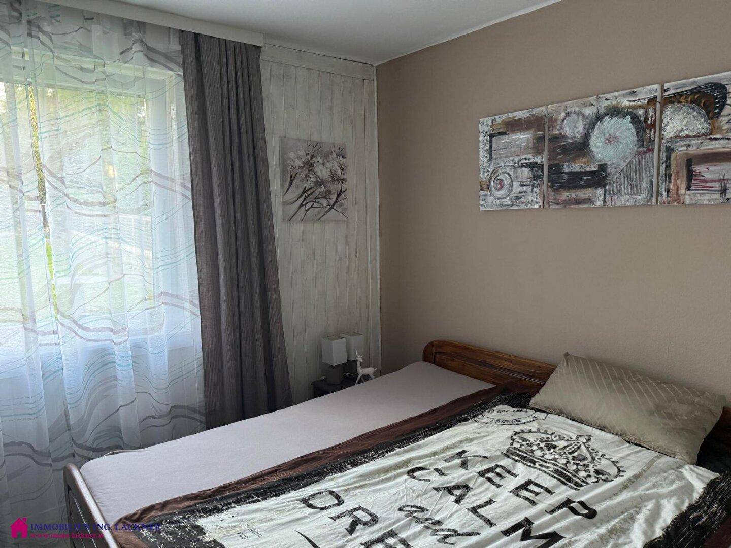 Gemütliches Schlafzimmer mit Einzelbett, hellen Wänden und Blick ins Grüne.