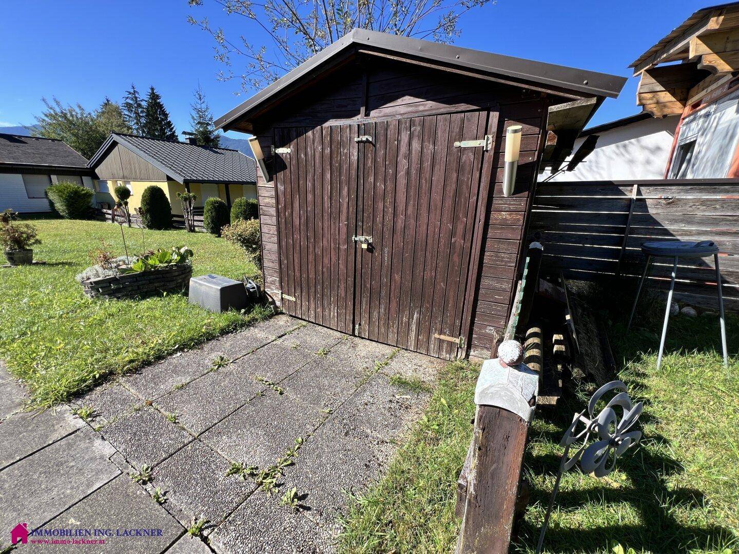 Rustikaler Holzschuppen im Garten, ideal zur Aufbewahrung von Gartengeräten.