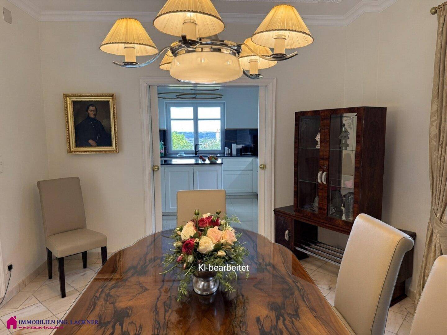 Elegantes Esszimmer mit großem Holztisch und Blick durch die Tür in die moderne Küche.