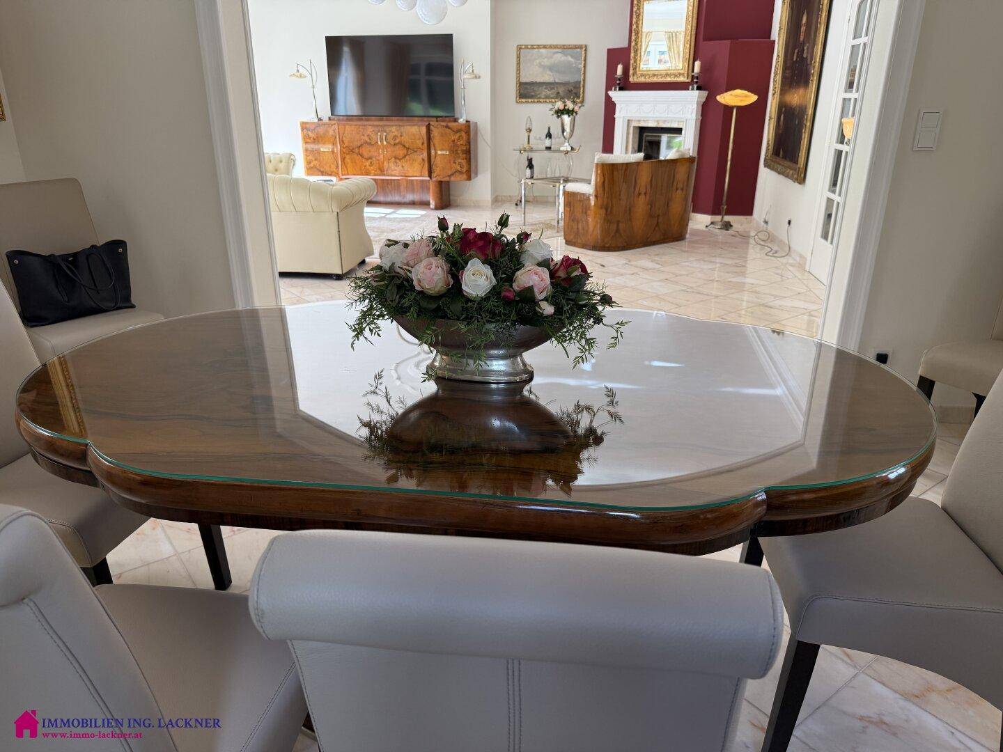 Esszimmer mit elegantem Tisch und Blick in den angrenzenden, stilvoll eingerichteten Wohnbereich.