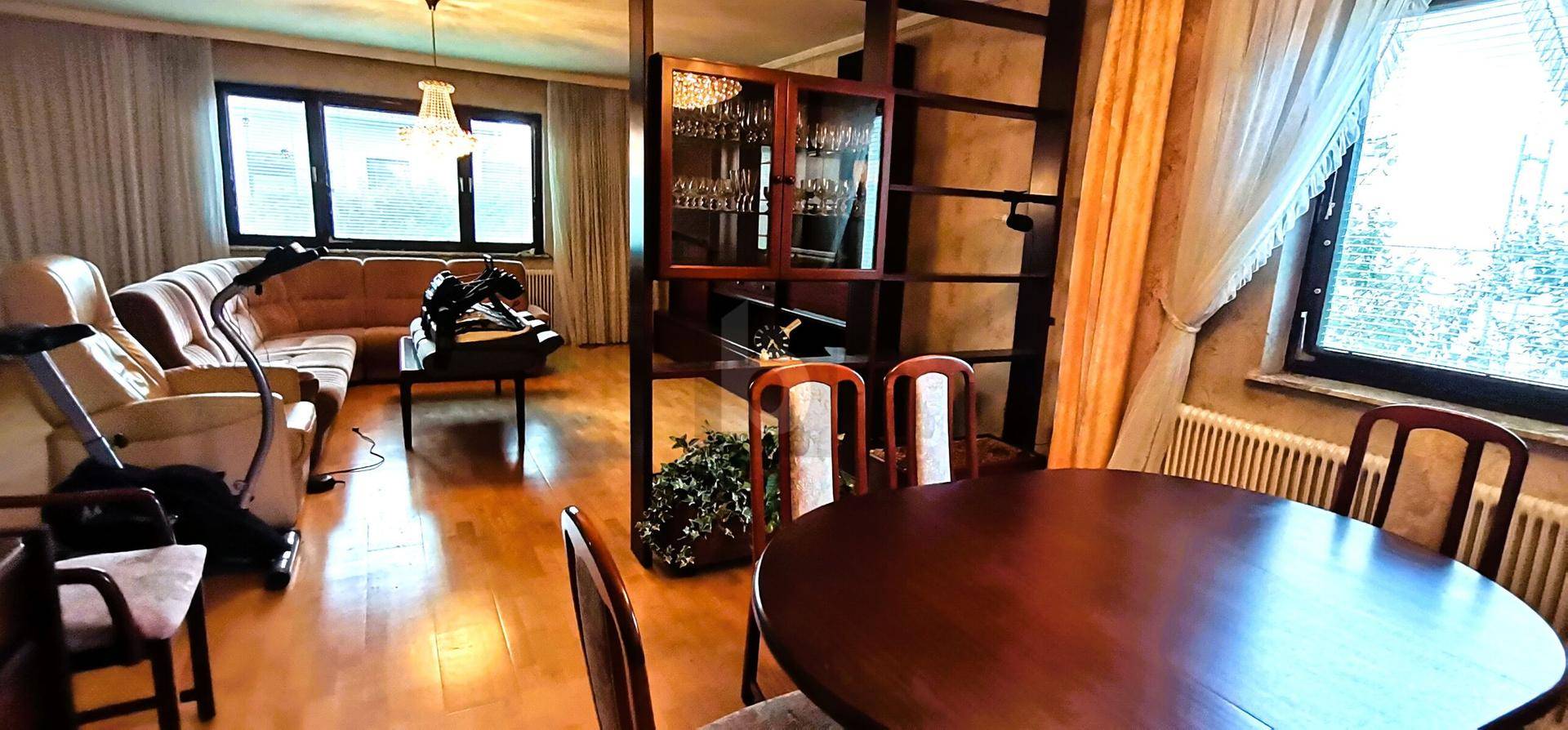 Gemütlicher Wohn- und Essbereich mit Holzboden und traditionellen Möbeln.