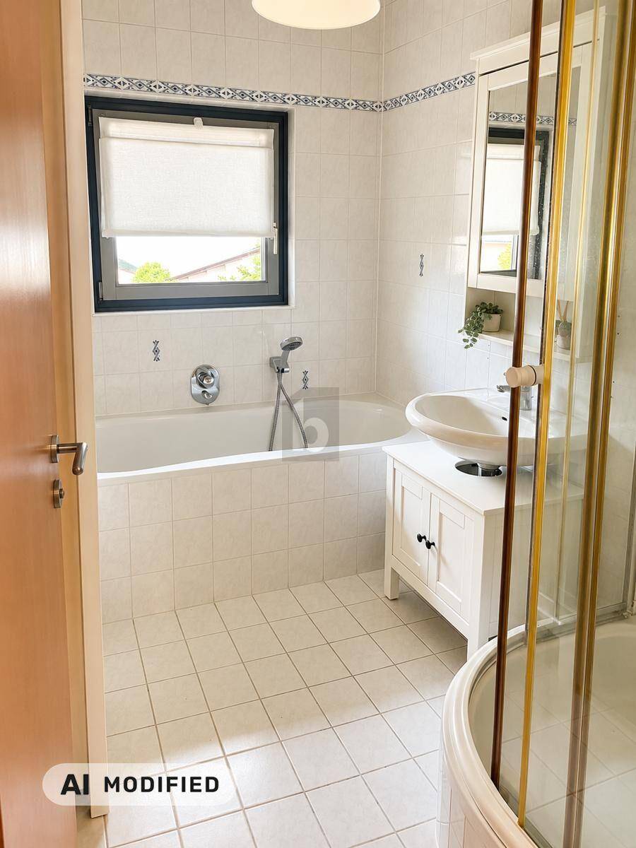 Helles Badezimmer mit Badewanne, Waschbecken, Spiegelschrank und Fenster.