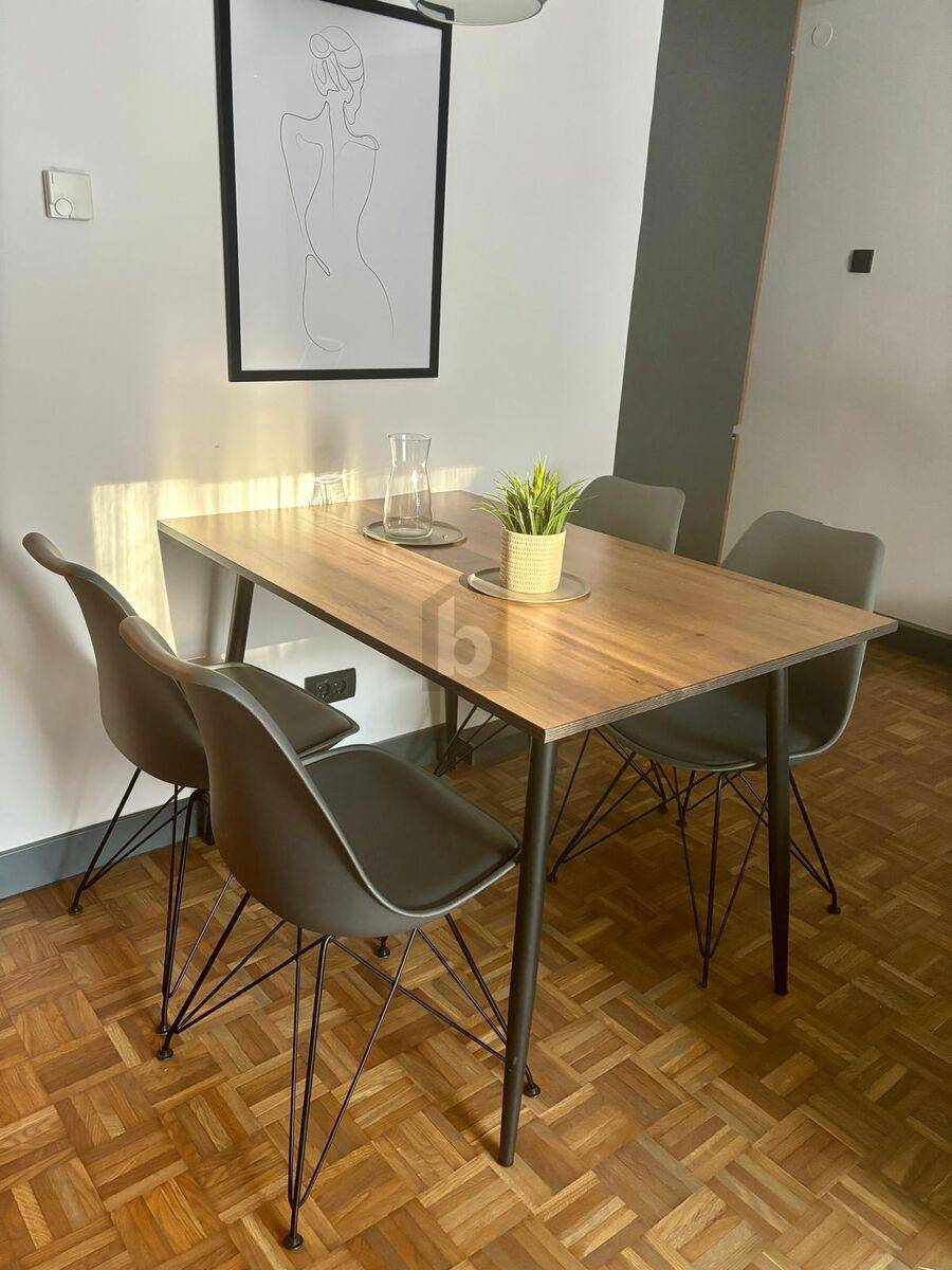 Heller Essbereich mit modernem Holztisch und vier Stühlen auf Parkettboden, ideal für Mahlzeiten.