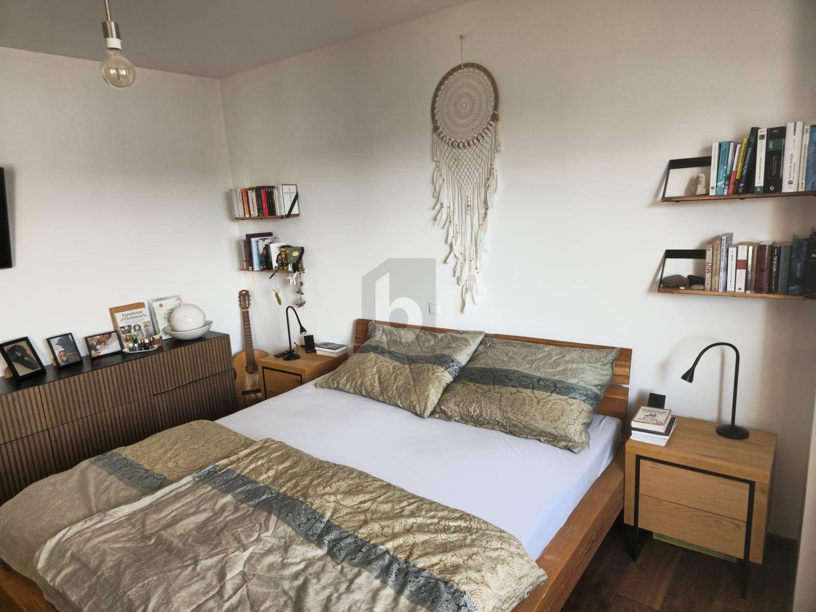 Helles Schlafzimmer mit Holzbett, Nachttischen und dekorativen Wandregalen.