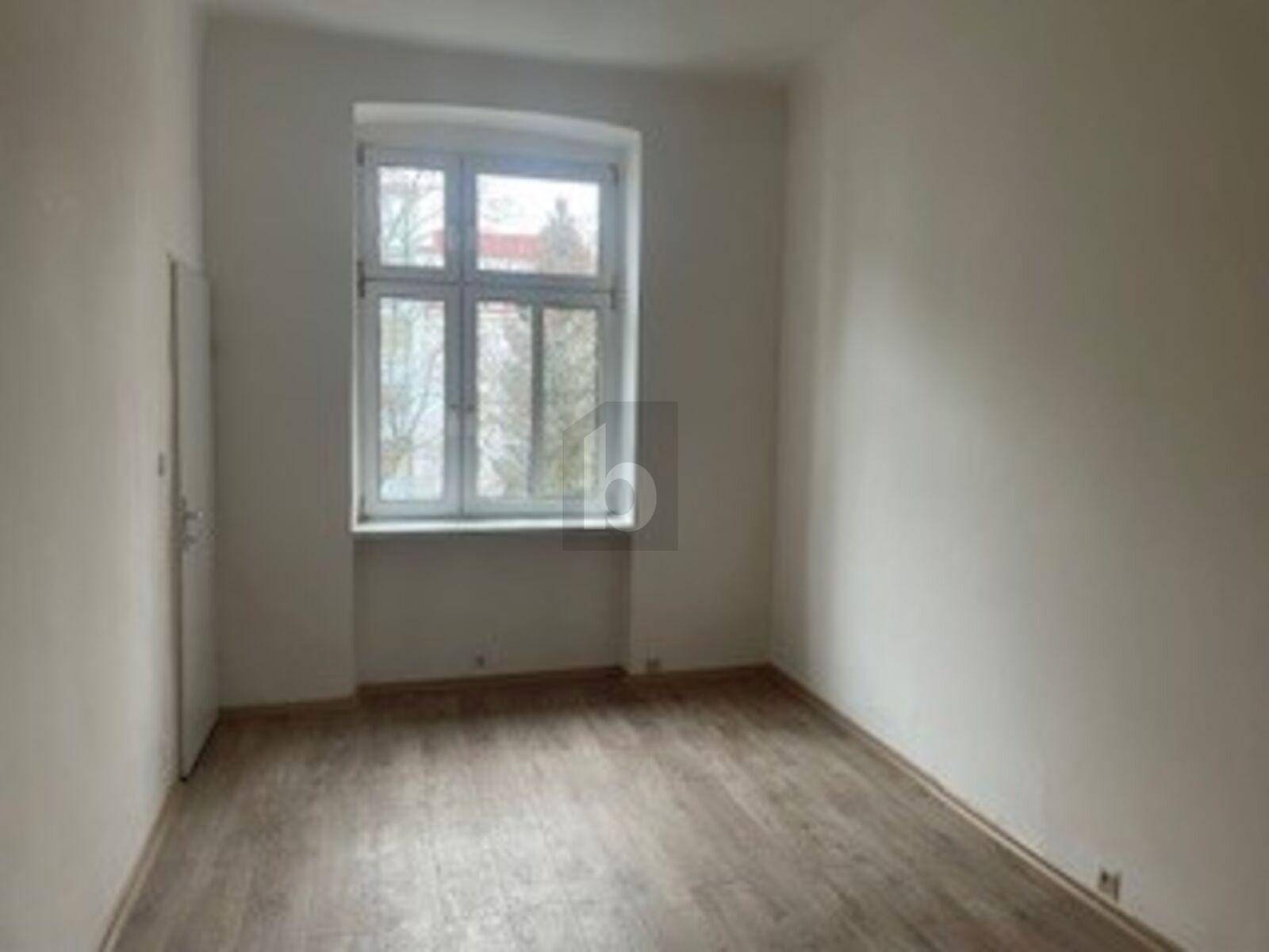 Geräumiger, heller Raum mit Laminatboden und großem Fenster, bereit zur individuellen Gestaltung.