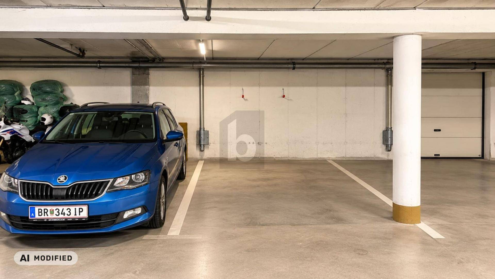Tiefgarage mit einem geparkten blauen Auto und ausreichend Stellplatz.