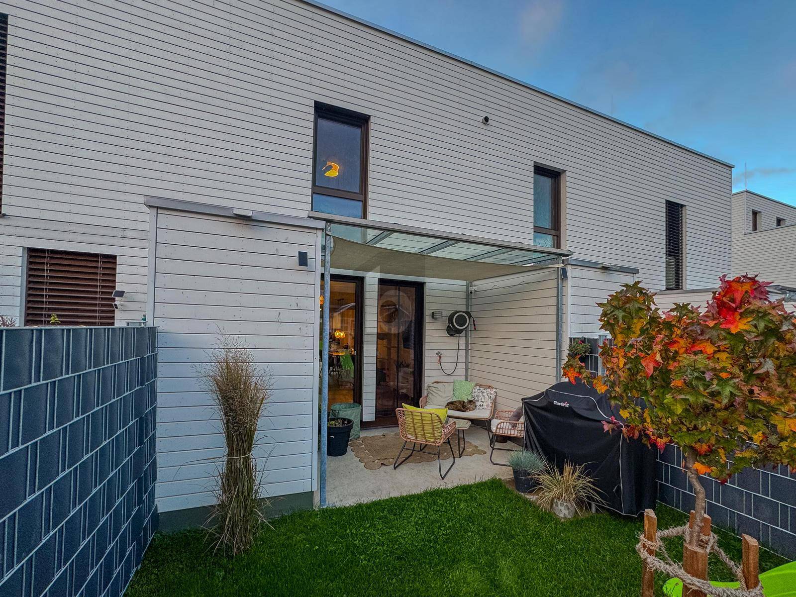 Gemütliche Terrasse mit Sitzgelegenheiten, Grill und Zugang zum Gartenbereich.