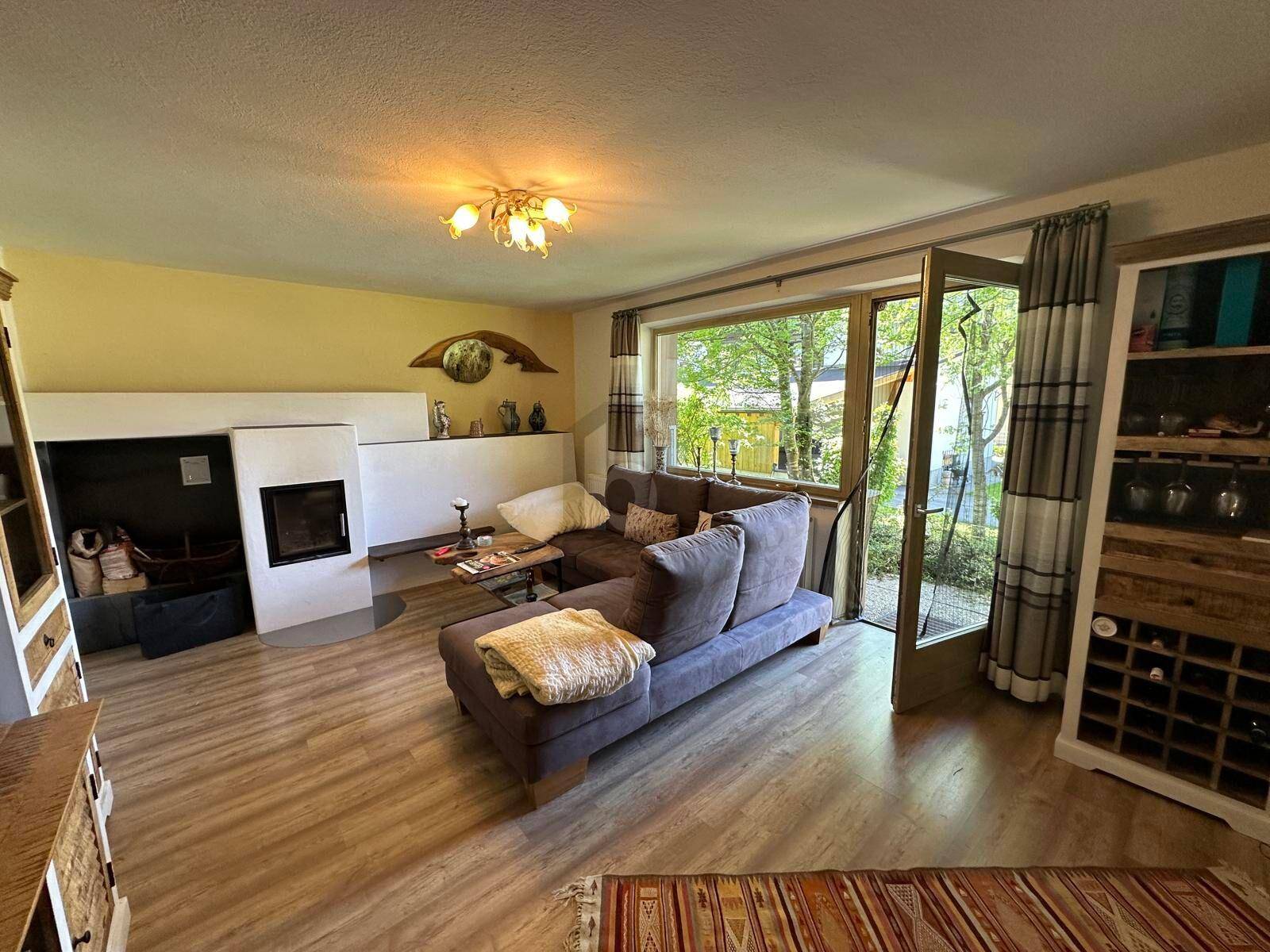 Gemütliches Wohnzimmer mit modernem Kamin, bequemer Couch und direktem Zugang zum Außenbereich.