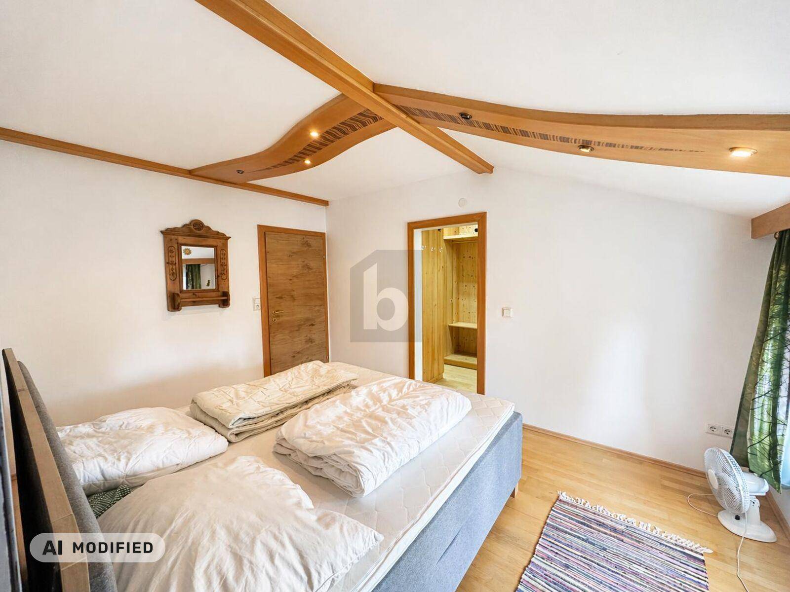 Gemütliches Schlafzimmer mit Holzbalkendecke, hellen Wänden und direktem Zugang zu einer Sauna.