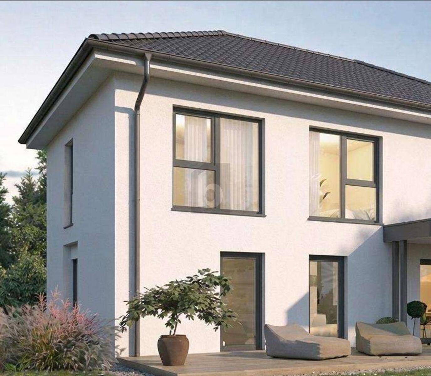 Moderne Hausfassade mit großen Fenstern und einer kleinen Terrasse im Erdgeschoss.
