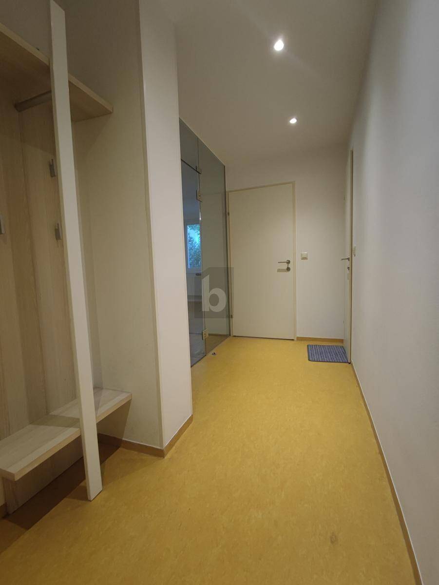 Heller Flur mit praktischer Garderobe, Einbauschränken und modernem Linoleumboden.