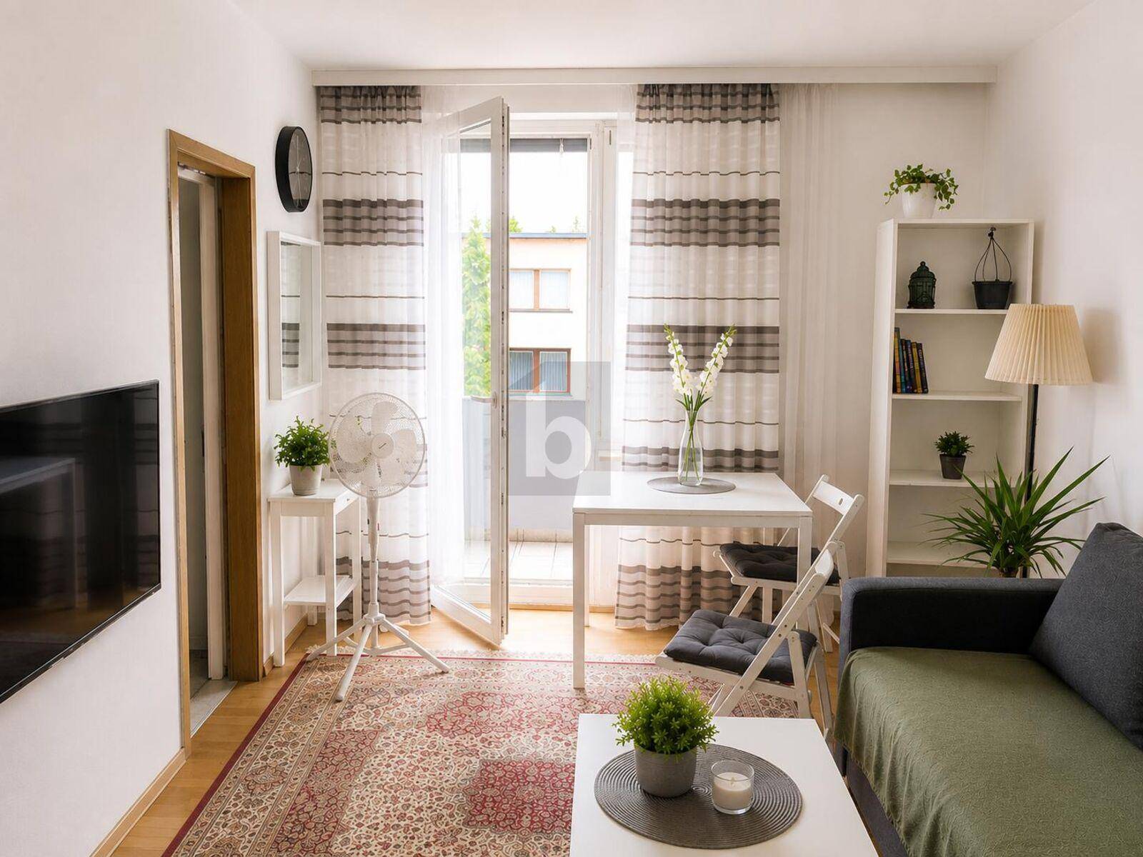 Helles Wohn-Esszimmer mit Teppichboden, Sofa, Esstisch und Zugang zum Balkon.