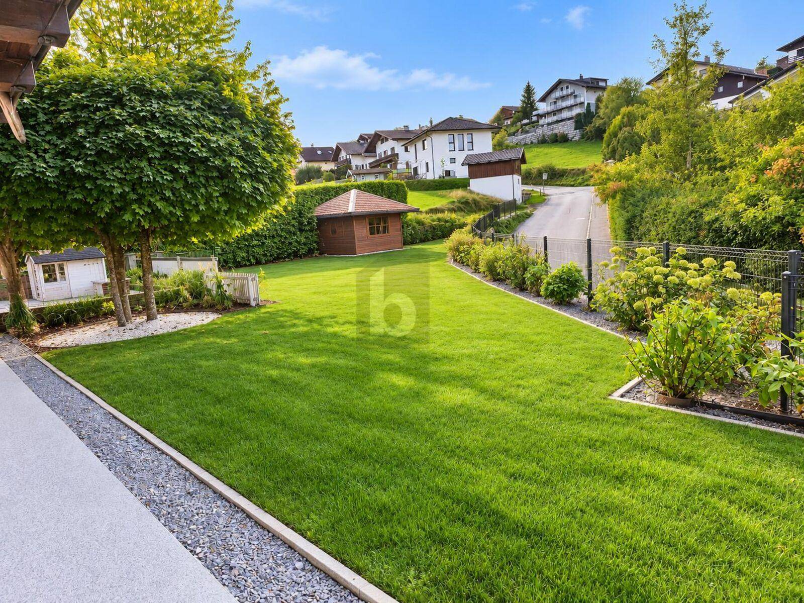 Gepflegter Garten mit großer Rasenfläche, Bäumen, Hecken und einem kleinen Gartenhaus.