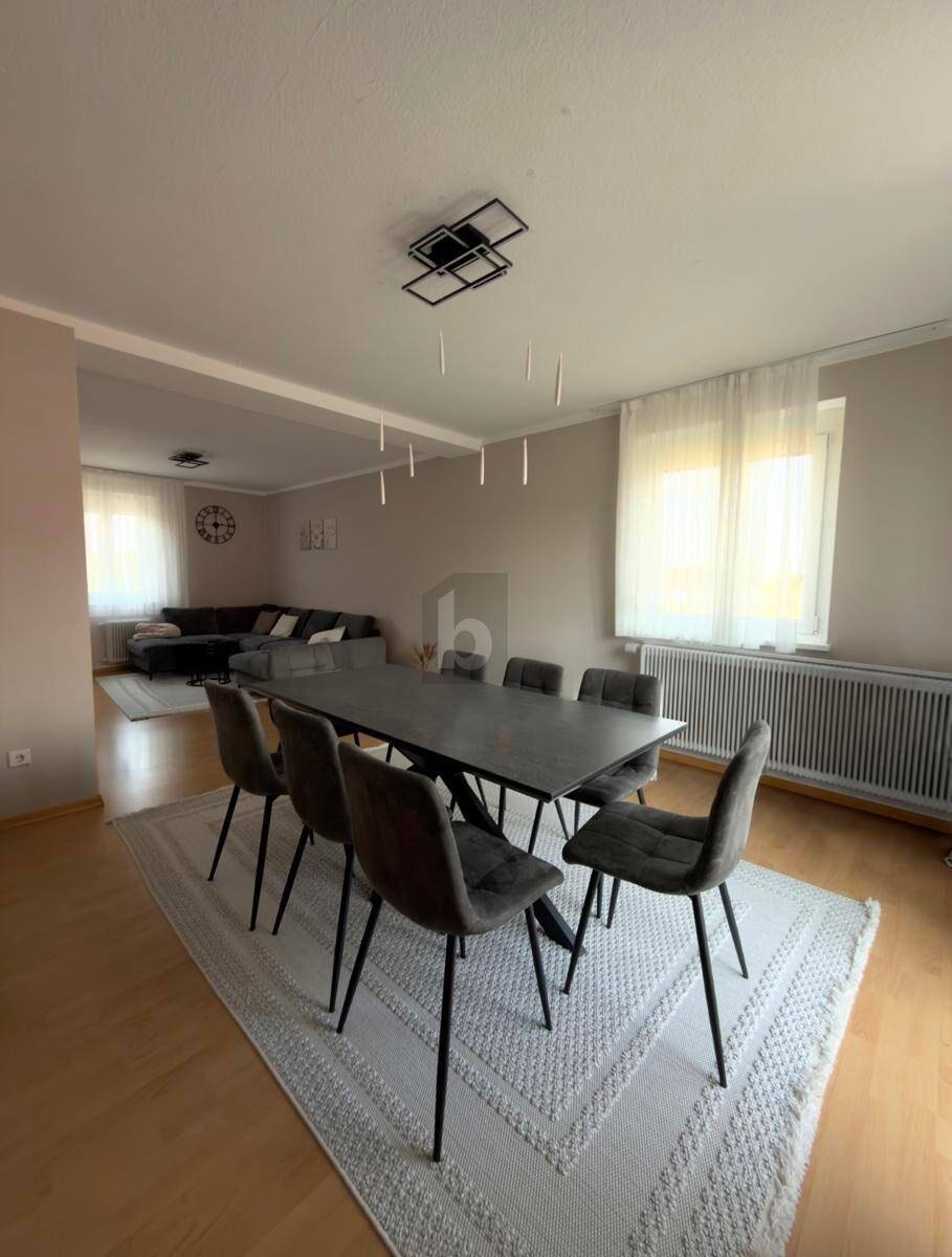 Geräumiger Essbereich mit großem Tisch und Stühlen, offen zum Wohnzimmer hin.