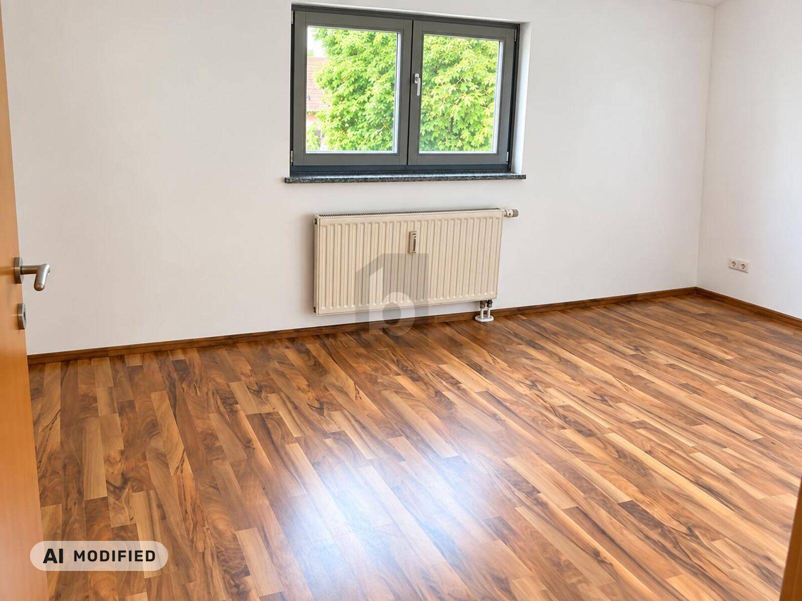 Leeres Zimmer mit Laminatboden, weiß gestrichenen Wänden und einem großen Fenster für viel Licht.