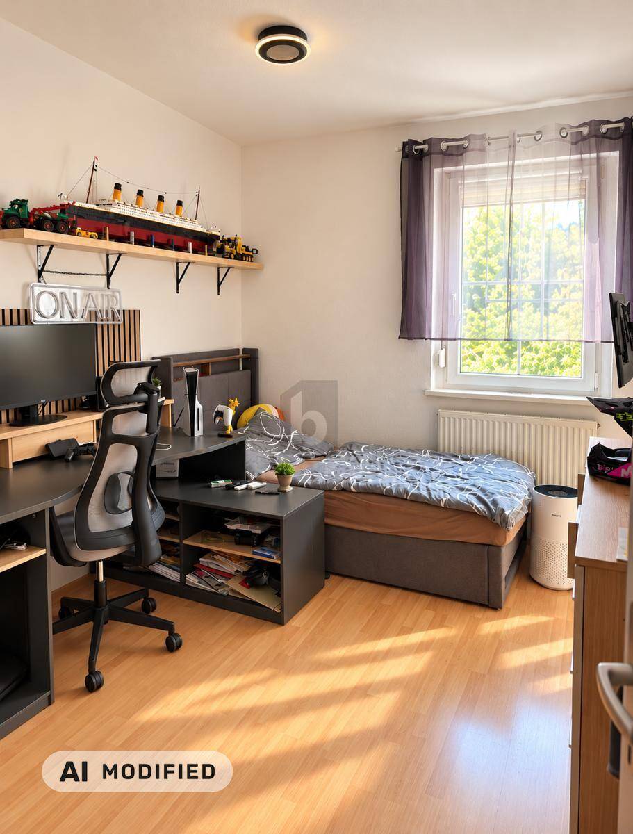 Jugendzimmer mit Bett, Schreibtisch und Regalen, hell durch großes Fenster.